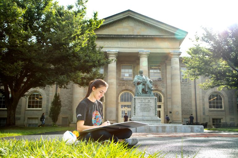 student studying on Cornell lawn